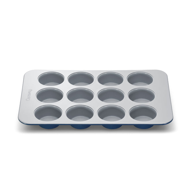 The Caraway Muffin Pan is a 12-cup metal baking tray with a safe gray non-stick surface and a blue silicone base.