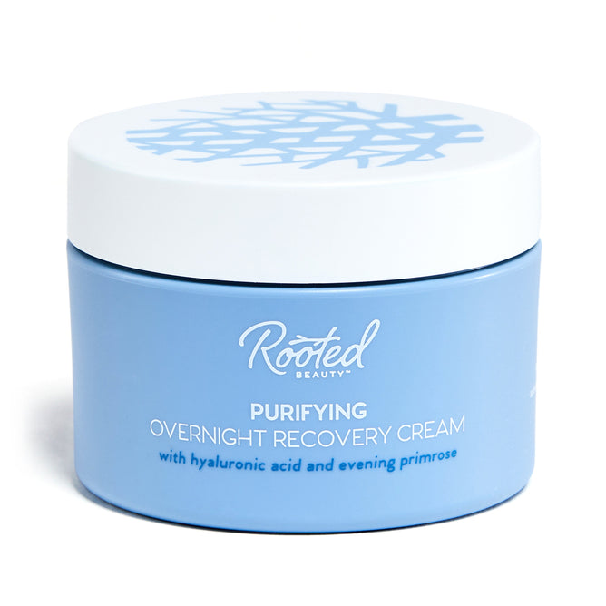 A blue jar of Rooted Beauty Purifying Overnight Recovery Cream contains R7 Complex, hyaluronic acid, and evening primrose. It features a white lid with an abstract flower-like pattern.