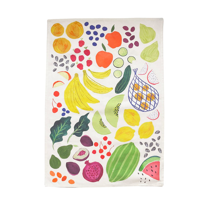 The Organic Cotton Tea Towel by Supra Endura showcases a vibrant design of colorful fruits like bananas, apples, lemons, and figs scattered on a white background, crafted from durable organic cotton.