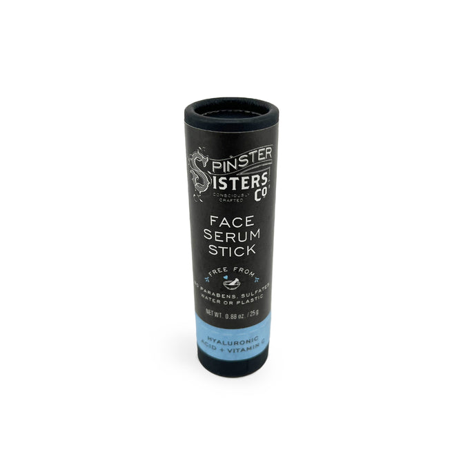 A black cylindrical tube labeled Spinster Sisters Co. Face Serum Stick showcases a formula free of parabens, sulfates, and phthalates. It contains hyaluronic acid, blue tansy oil, and vitamins, with packaging weighing 0.5 oz or 15 g.